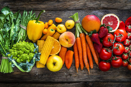 drewniany stół pełen świeżych warzyw, owoców i zdrowych produktów
