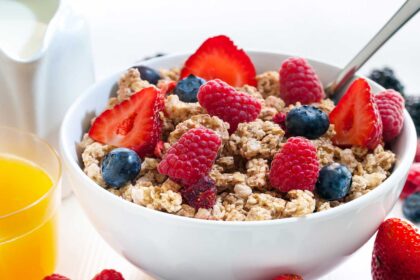 Zdrowe śniadanie z owsianką, owocami i orzechami na drewnianym stole