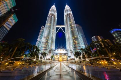 Panoramiczny widok na Kuala Lumpur z Petronas Towers i nowoczesną architekturą w tle.