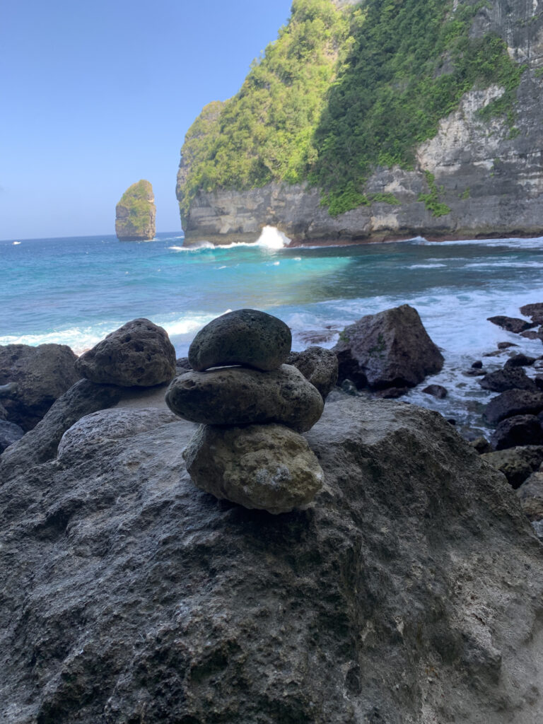 Kamienie na sekretnej plaży Nusa Penida z tłem pięknej turkusowej wody i klifami