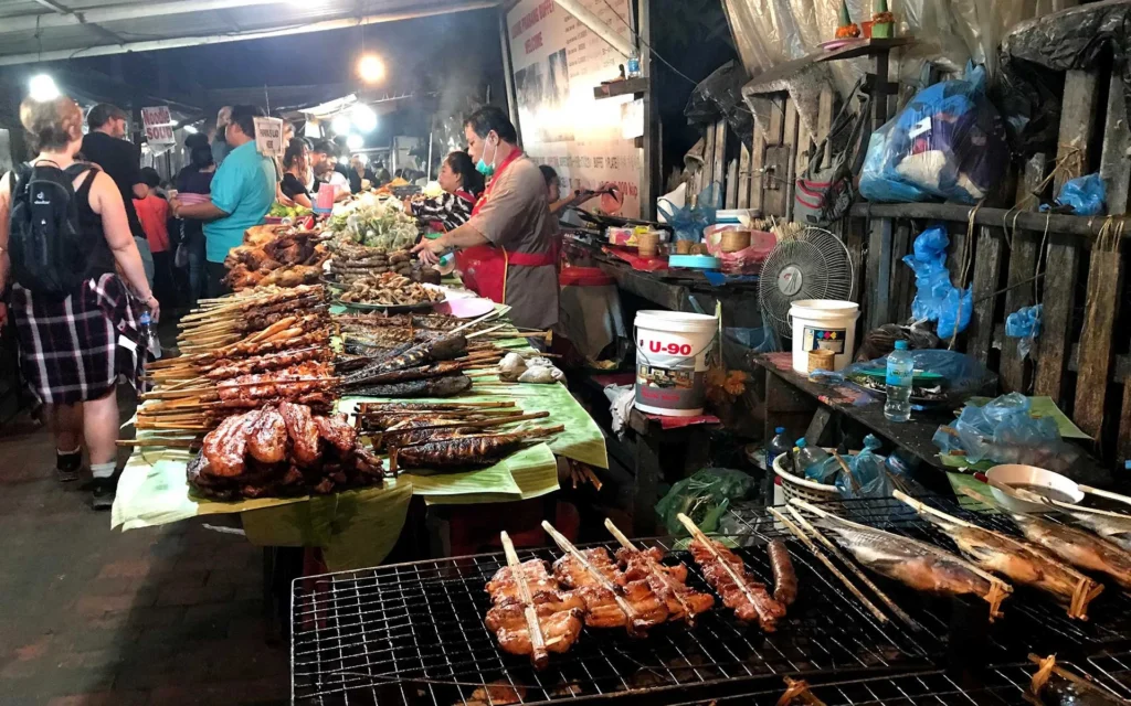 Laos street food na nocnym targu – grillowane mięso i ryby na bambusowych patyczkach w Luang Prabang