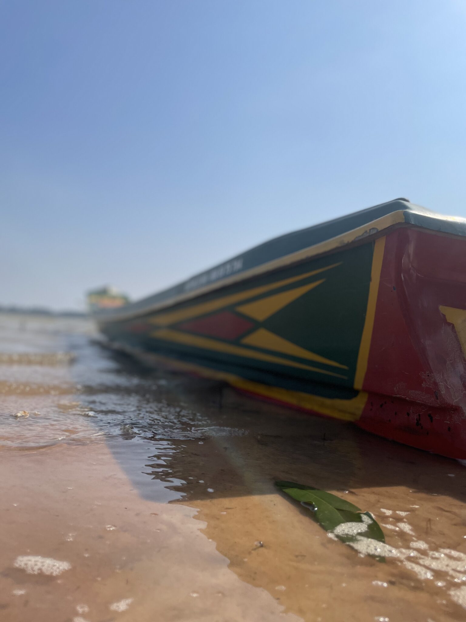 Kolorowa drewniana łódź na piaszczystym brzegu jeziora West Baray w Kambodży.