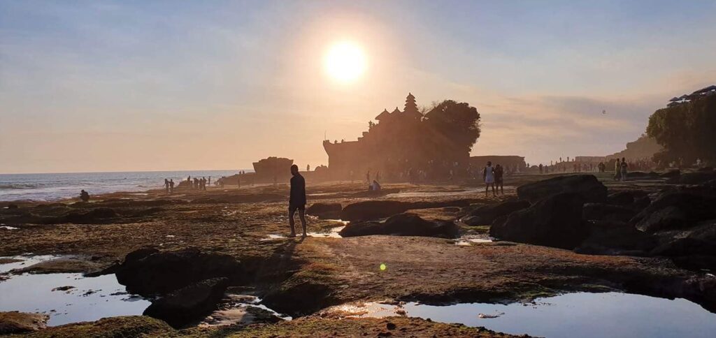 HOW MUCH IS A LIFE WORTH IF YOU DON'T HAVE TIME TO LIVE IT? 8 Silhouette of a person watching the sunset over the ocean.