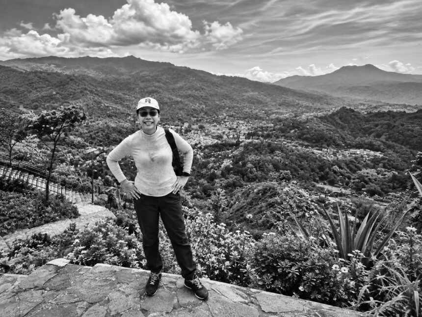 Shades of Human Life #7 - Dayu Murtini standing against a mountain landscape in Bali